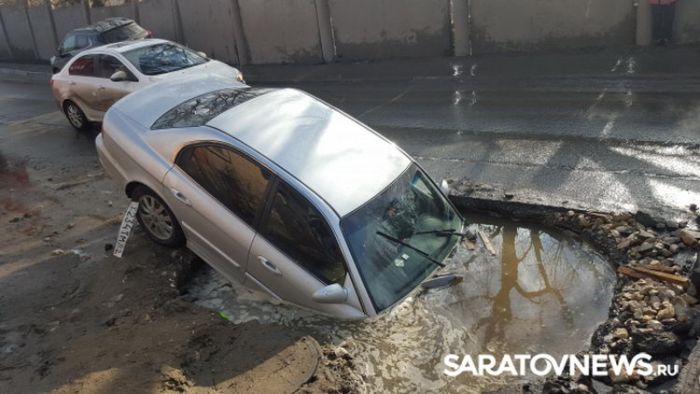 В Саратове автомобиль провалился в огромную яму на дороге (6 фото) В Саратове автомобиль провалился в огромную яму на дороге (6 фото)